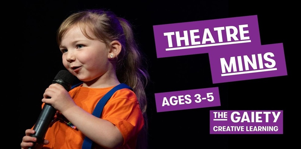 A young girl with light brown hair in a ponytail is speaking into a microphone on stage. She is wearing an orange shirt with blue suspenders and small earrings. The background is dark, and there are bold purple text boxes on the right that read: "THEATRE MINIS", "AGES 3–5", and "THE GAIETY CREATIVE LEARNING.