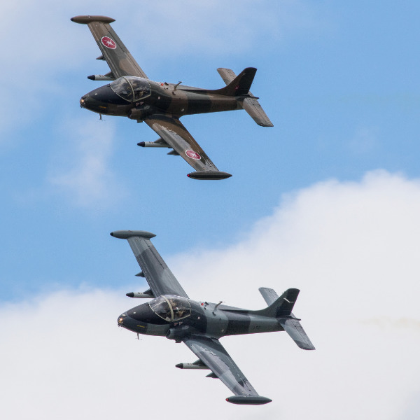 Two Strikemaster aircraft in flight.