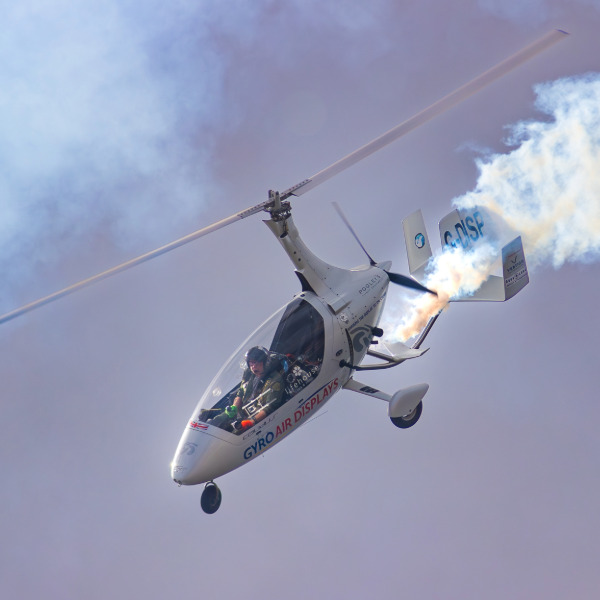 Calidus Autogyro in flight with smoke trail.