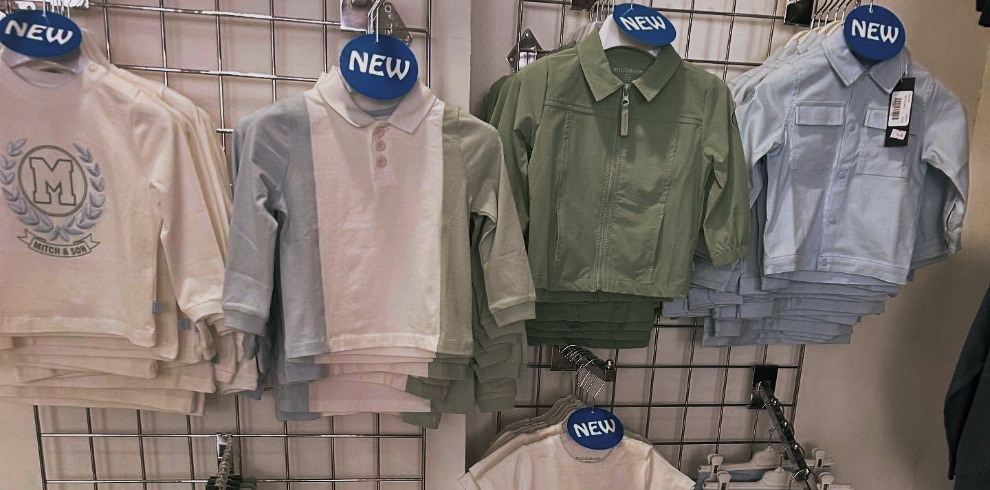 Images of children's clothes hanging on a rail.