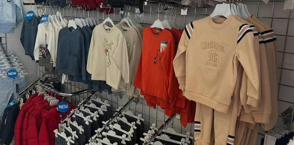 Images of children's clothes hanging on a rail.