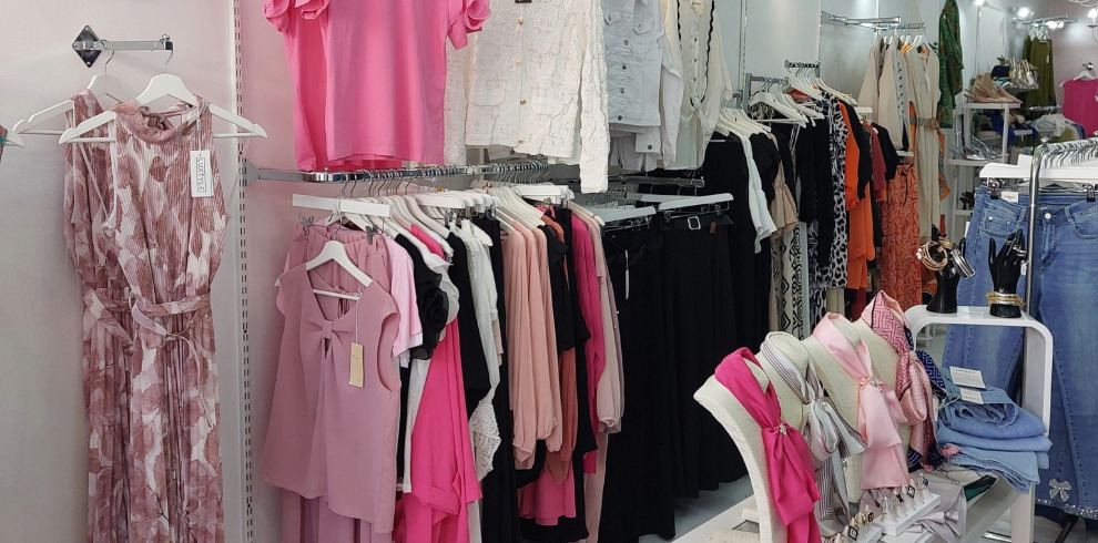 Clothing boutique interior wih rails of clothes.