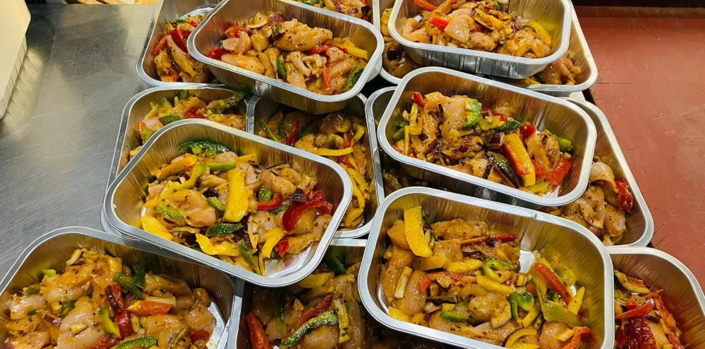A variety of stir fry food in trays.