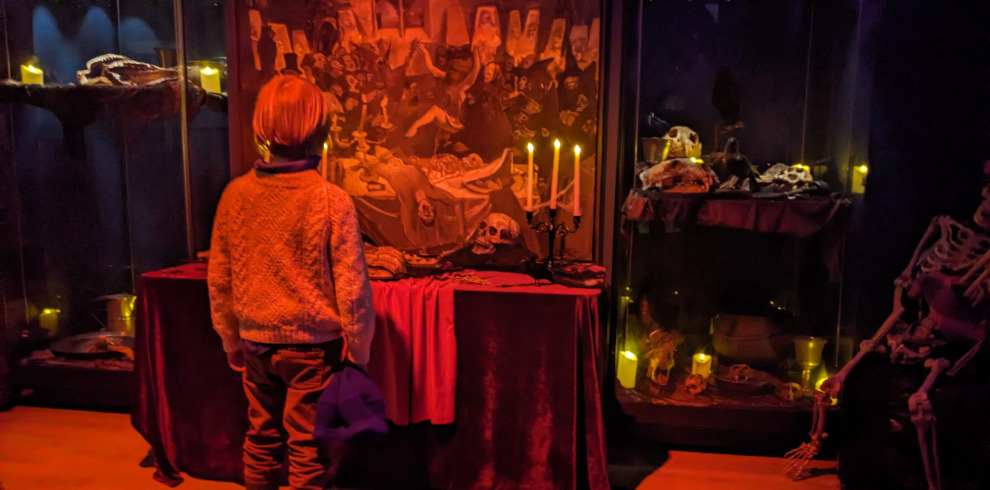 Red lighting spooky scene of child looking at painting