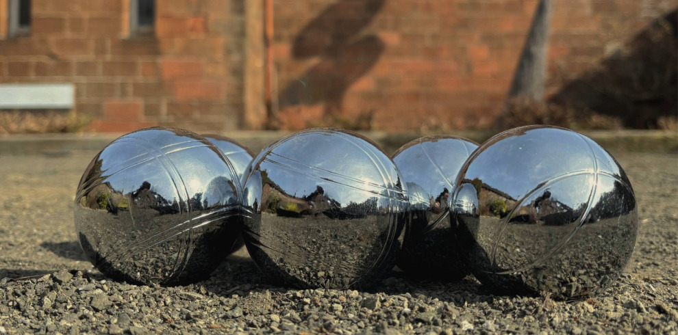 Boules grouped together on gravel.
