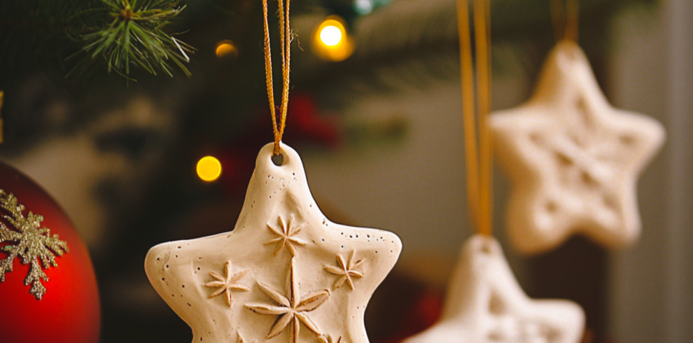 An image of decorations made out of clay hanging from a Christmas tree.