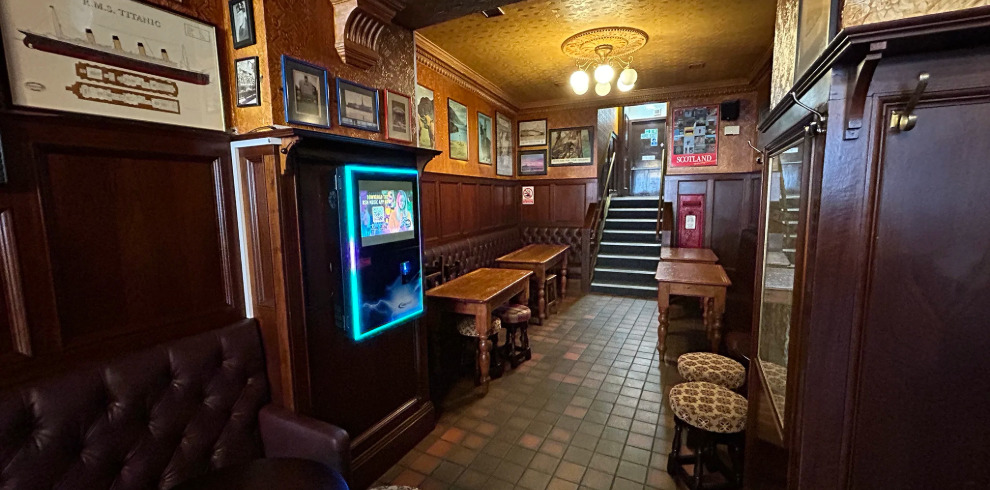 Interior of bar area with tables, stools and juke box.