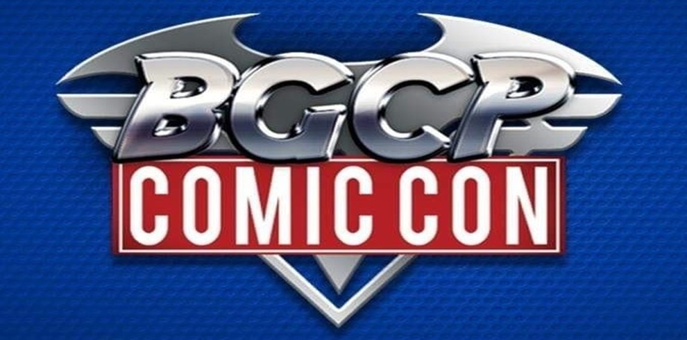 The logo features the letters "BGCP" in large, metallic, silver-colored, three-dimensional capital letters, designed with a Batman-style bat symbol integrated into the top edge. Below this, the words "COMIC CON" appear in white, capitalized, bold letters within a red rectangular banner that is outlined in white. The entire design is set against a deep blue, textured background with subtle lighting effects.