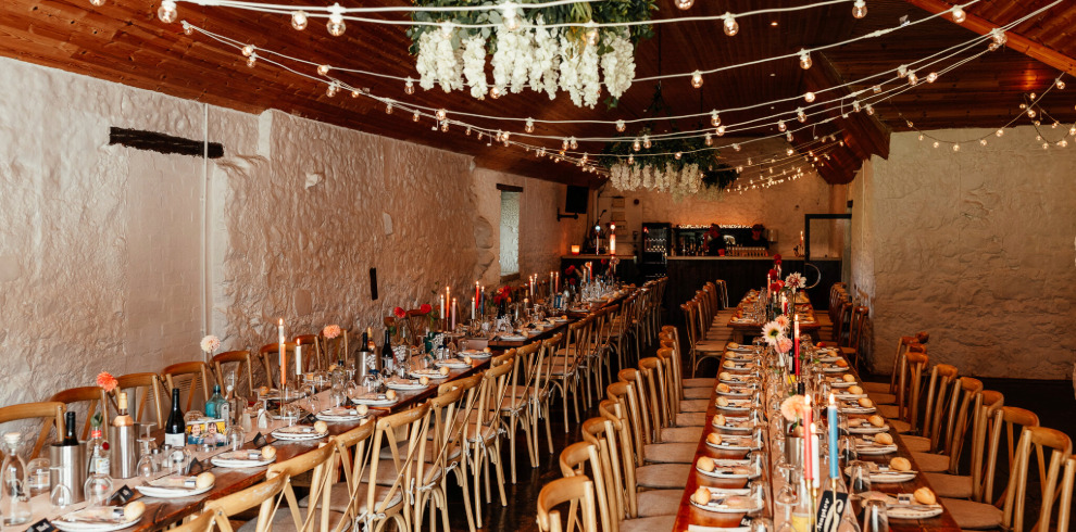 Tables set for a meal in a barn.