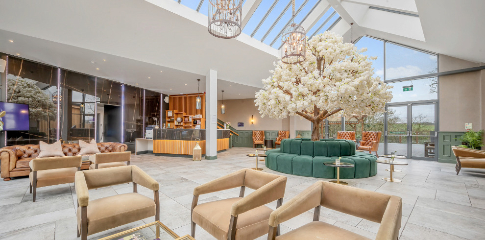 Enterkine Country House Resort 1 Large reception room with glass ceiling and seating.