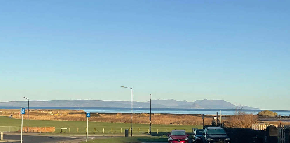 Blue skies and sea views with mountains in distance.
