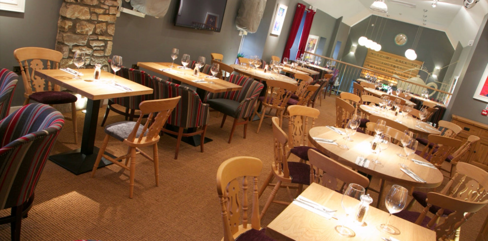 Restaurant dining area with wooden table and chairs.