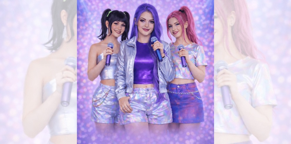 3 woman holding microphones surrounded by a purple glittery background.