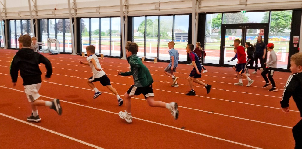 Children running on an indoor sports track.