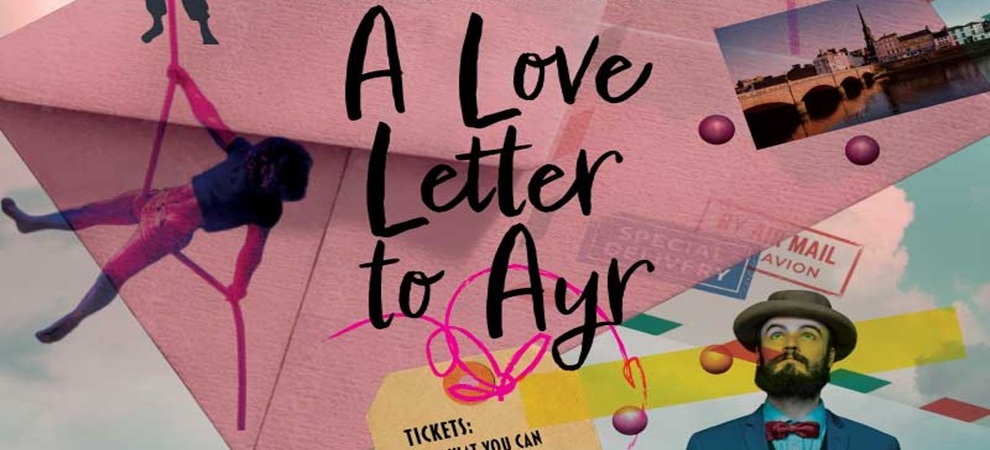 A colourful promotional poster featuring the title “A Love Letter to Ayr” in bold, handwritten-style black lettering. The background includes overlapping elements such as a large pink envelope, postage stamps, and a scenic photograph of a riverside town. On the left, a performer is shown suspended in the air on long pink stilts. On the right, a figure wearing a hat, suit jacket, bow tie, and patterned shirt stands against a sky with scattered clouds. Bright decorative shapes, doodles, and ticket-style graphics are scattered throughout the design, creating a lively, collage-like aesthetic.