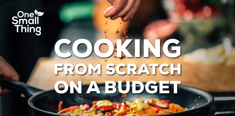 Promotional graphic titled ‘Cooking from Scratch on a Budget’. The background shows a close-up of a hand sprinkling seasoning into a frying pan filled with colourful vegetables. In the upper-left corner is the ‘One Small Thing’ logo with a small leaf icon.