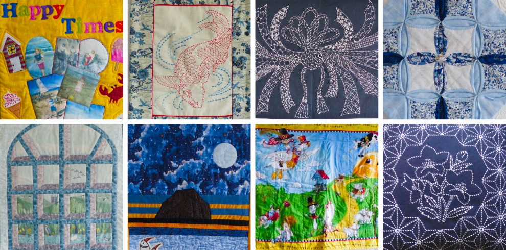 A collage of eight quilt squares arranged in two rows of four. The designs vary in color and technique. Top row: a bright yellow quilt featuring the words “Happy Times” with appliqué houses, figures, and shapes; a cream and blue quilt with a red stitched outline of a bird; a dark blue quilt with intricate white stitched geometric and floral patterns; and a blue-and-white quilt with folded circular fabric pieces forming a symmetrical pattern. Bottom row: a light blue arched-window-style quilt with small landscape scenes in each pane; a night scene quilt showing a moonlit sky, dark rock formation, and ocean with a small boat; a colorful storybook-like quilt depicting people, animals, and umbrellas on a grassy hill; and a dark blue quilt with white stitched flower and star-like patterns.