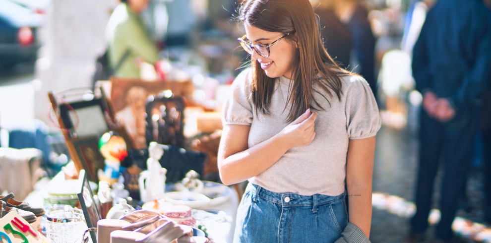 Woman browsing a table of bric-a-brac.