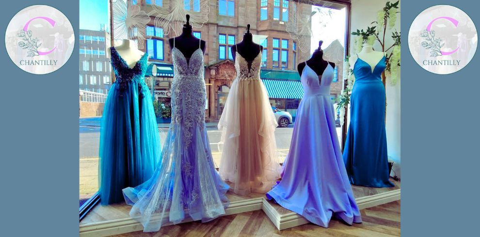 A shop window showcasing various prom dresses.
