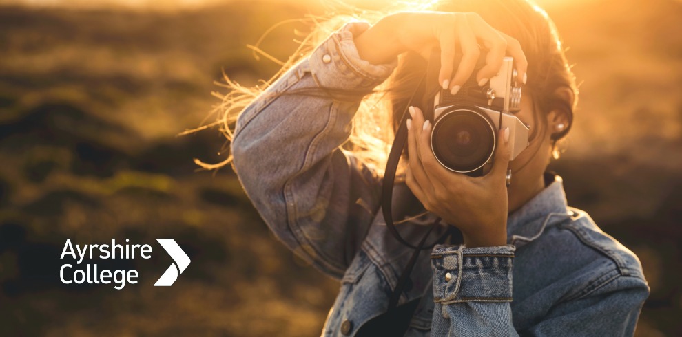 Woman holding camera outside taking a photo.