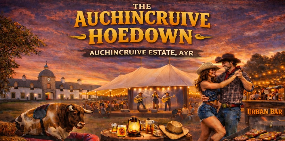 Promotional artwork for “The Auchincruive Hoedown” at Auchincruive Estate, Ayr. In the foreground, two people in cowboy-style hats and country clothing dance beside a wooden table with drinks and a hat. A large bull lies nearby, and barbecue food cooks at a stand labeled “Urban Bar.” In the background, a lit marquee tent hosts a live band, with a historic estate building behind it, all set against a warm sunset sky.