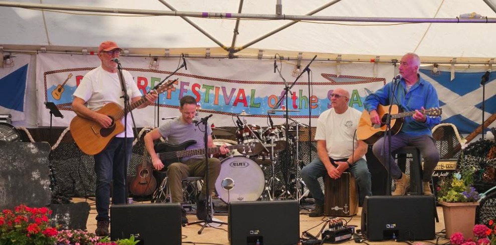 Band performing on an open air stage.