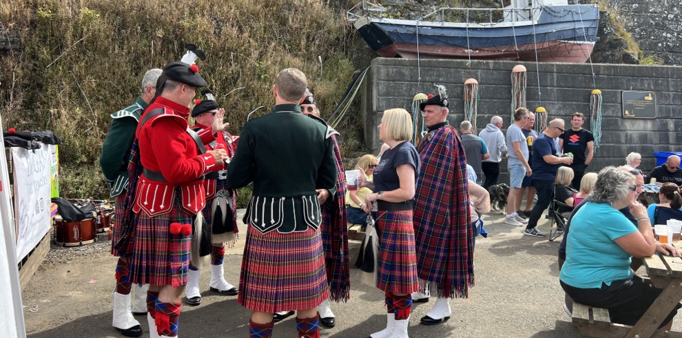 Pipers playing at a small outdoor festival.