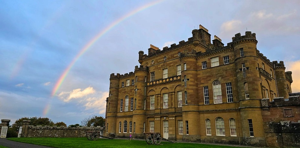 Large castle with a rainbow in the sky above it.