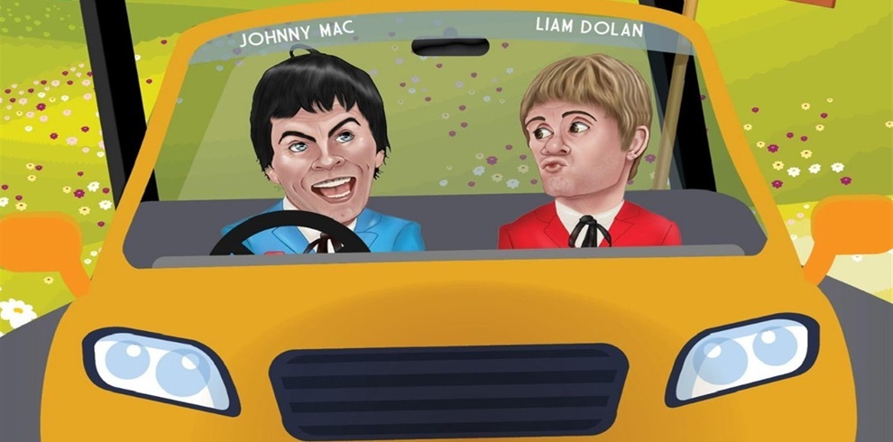 Illustrated promotional image showing two caricature-style performers seated in a yellow car, viewed from the front. The character on the left is driving, with the name ‘Johnny Mac’ written above, and the character on the right sits in the passenger seat, with the name ‘Liam Dolan’ above. The background features a bright, countryside-style scene with flowers and greenery, creating a playful, comic road‑trip theme.