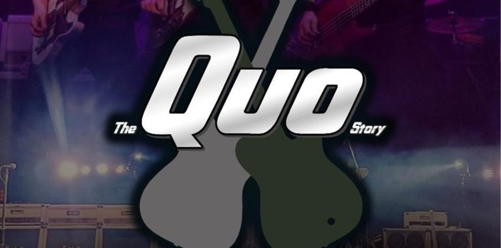 Promotional image for The Quo Story. Bold silver text reading “Quo” with smaller text “The” on the left and “Story” on the right sits over two overlapping guitar silhouettes in grey and dark green. The background shows a dimly lit concert stage with amplifiers and musicians’ hands holding guitars, washed in purple and blue stage lighting.