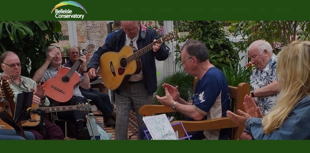 An image of a group of people playing music and singing in a conservatory.