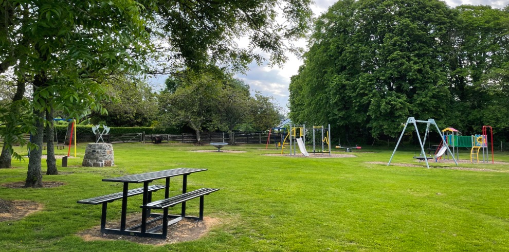 Children's outdoor play park on a bright sunny day. Picnic seating area.