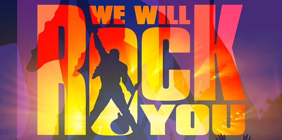 Bold, colorful concert-style graphic with large text reading “WE WILL ROCK YOU.” The letters are filled with warm gradient tones of red, orange, and yellow, resembling stage lighting. In front of the text, a dark silhouette of a performer stands holding a guitar, legs apart in a dynamic pose. Background elements include bright light flares and faint silhouettes of raised hands, suggesting a live music crowd atmosphere.