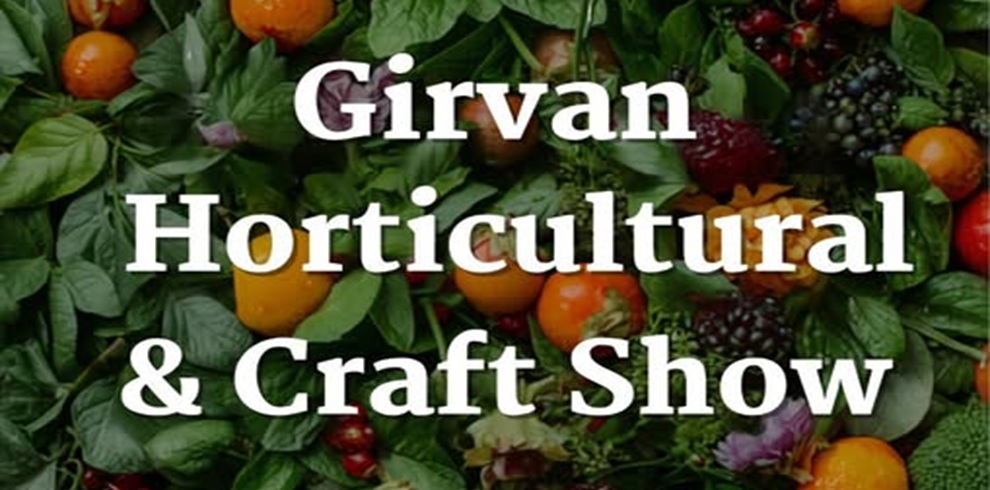 Poster for the Girvan Horticultural & Craft Show featuring large white text centered over a vibrant background of fresh fruits, vegetables, herbs, and flowers. The greenery includes leafy plants and colorful produce such as tomatoes, berries, and citrus, creating a lush, garden-themed design. The text is bold and easy to read, with “Girvan Horticultural & Craft Show” prominently displayed against the rich, natural backdrop.