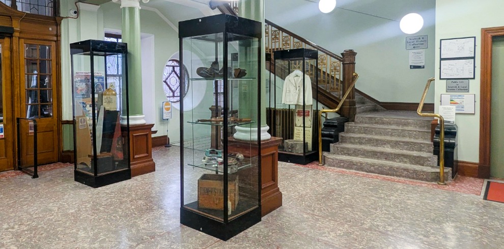 Display cabinets with museum artefacts on display in a large hallway.