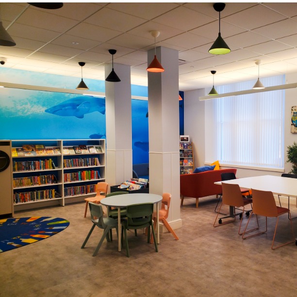 Interior of library, with bookshelves and seating area.