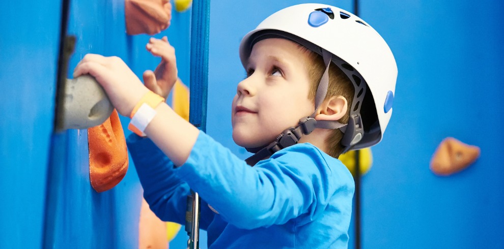 Small girl on a climbing wall.