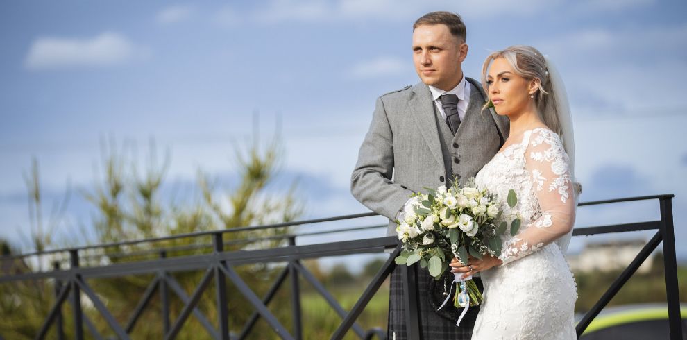 An image of a bride and groom outside on a sunny day.