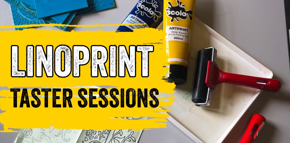 Promotional graphic for “Linoprint Taster Sessions.” The image shows two tubes of block-printing ink (blue and yellow), a white ink tray, and two red-handled brayers (rollers) arranged on a light grey work surface with sketch paper visible underneath. Bold black-and-white text reading “LINOPRINT” and “TASTER SESSIONS” appears over a bright yellow paint-stroke background on the left side of the image. The overall design has a creative, workshop-style feel.