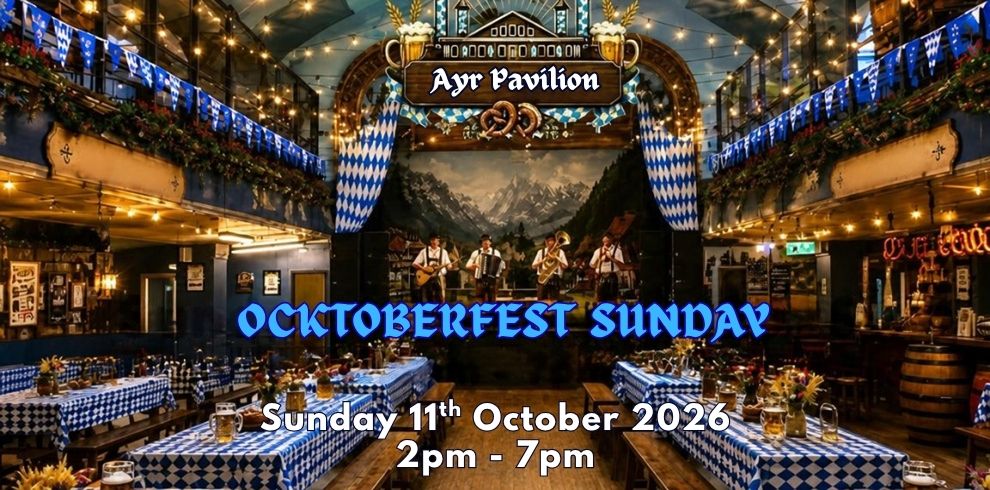 Promotional image for an Oktoberfest-style event at Ayr Pavilion. The venue is decorated with blue and white Bavarian-themed bunting and long wooden tables covered in blue and white checkered tablecloths. Warm string lights hang across the ceiling, illuminating the large hall. A stage at the far end features a live band performing beneath an ornate “Ayr Pavilion” sign, with a mountain scene backdrop behind the musicians. Beer steins and floral centrepieces are arranged on the tables. Large white text over the image reads: “Sunday 11th October 2026.” The atmosphere is festive and traditional, with Bavarian-inspired décor throughout the venue.