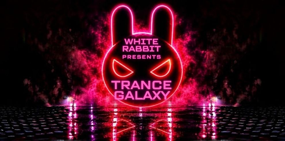 Promotional graphic for White Rabbit Presents: Trance Galaxy. A glowing neon pink rabbit-face logo with long ears dominates the centre of the image against a dark black background. Pink smoke and light effects surround the logo, creating a futuristic nightclub atmosphere. The text reads “WHITE RABBIT PRESENTS” above “TRANCE GALAXY” in bold neon lettering. The reflective floor below mirrors the bright pink lights and circular patterns, enhancing the energetic electronic music theme.