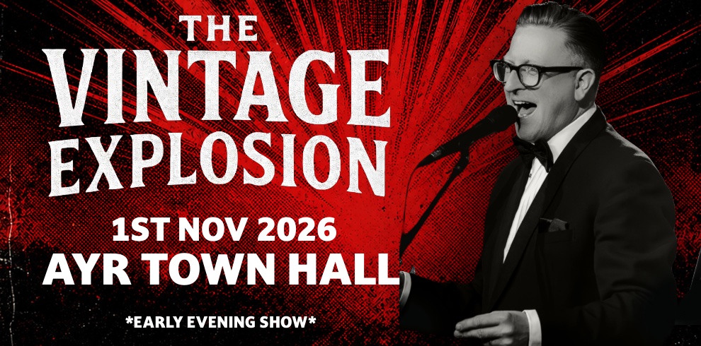 Promotional poster for The Vintage Explosion featuring a vintage-style red and black background with bold white lettering. The text reads: “The Vintage Explosion”, “1st Nov 2026”, “Ayr Town Hall”, and “Early Evening Show”. On the right, a performer in a tuxedo stands at a microphone. The overall design has a retro rock and roll and rhythm and blues theme.