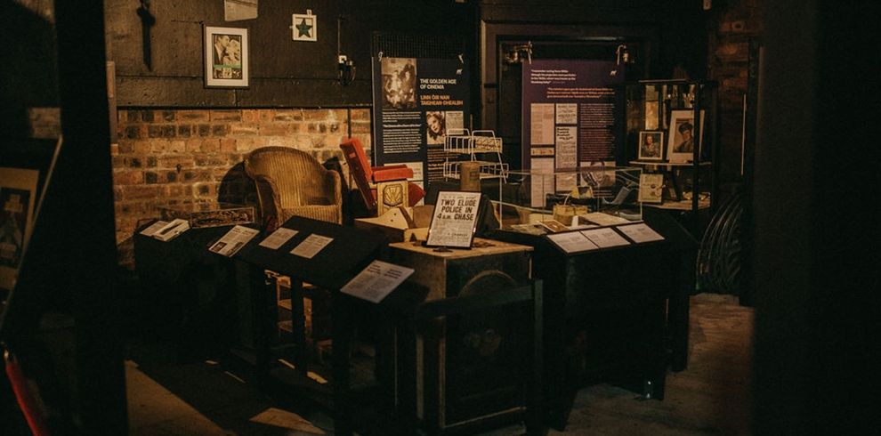 Museum exhibition showcasing cinema memorabilia, archive materials, photographs, posters and artefacts related to the Broadway's history. Informational display boards and historic items are arranged throughout the warmly lit gallery space.