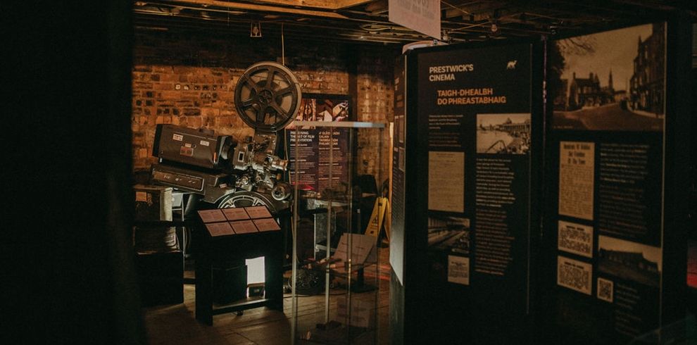 Display area within the Broadway Pop-up Museum featuring a vintage film projector, heritage exhibition panels and historic photographs. The exhibition explores the history of Prestwick's cinema and the restoration of the Broadway.
