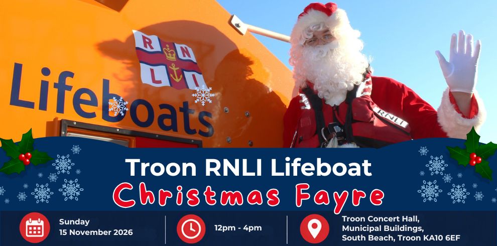 Santa Claus visits the RNLI lifeboat station, smiling beside RNLI volunteers in bright yellow safety gear, celebrating the festive season while highlighting the charity's lifesaving work along the coast.