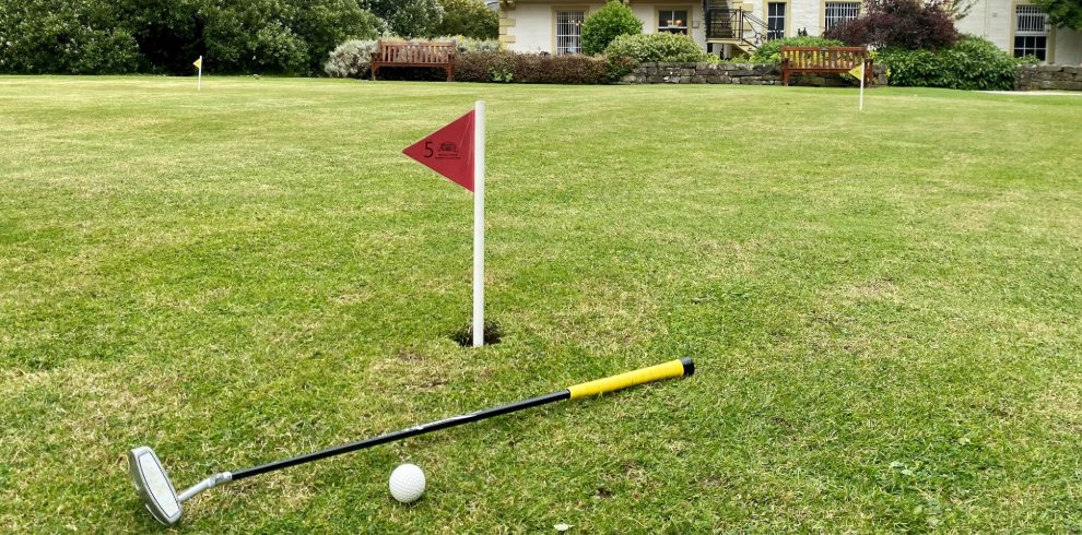 Golf putting green with ball and putter.