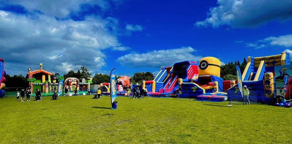 A picture of Bounce on the Park inflatables in the park with blue skies.