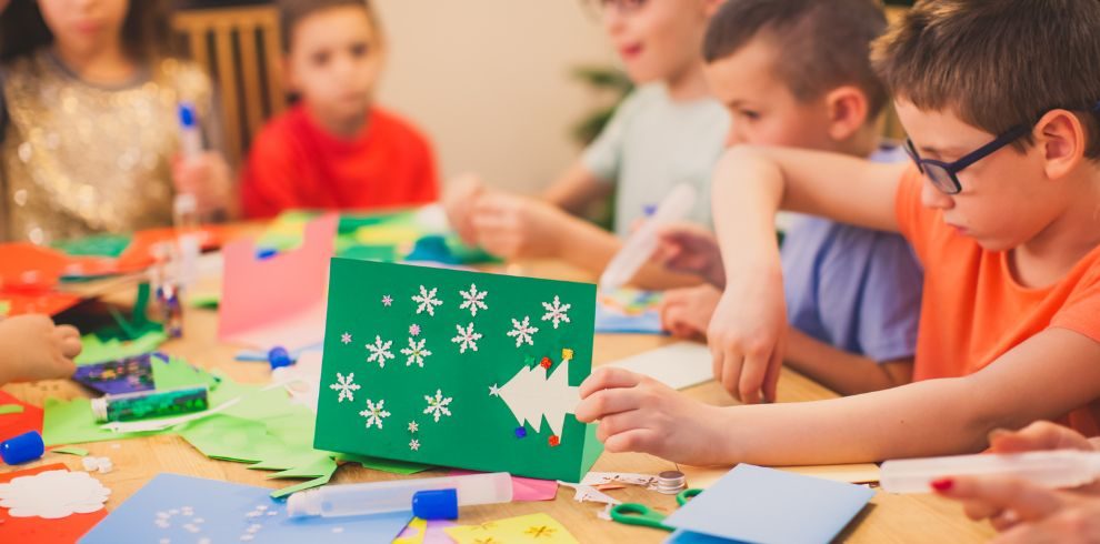 A picture of young people sitting at a table getting creative with Christmas Crafts.