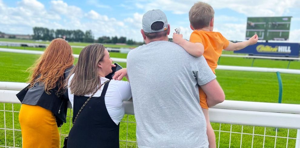 A photograph of a family watching horseracing.