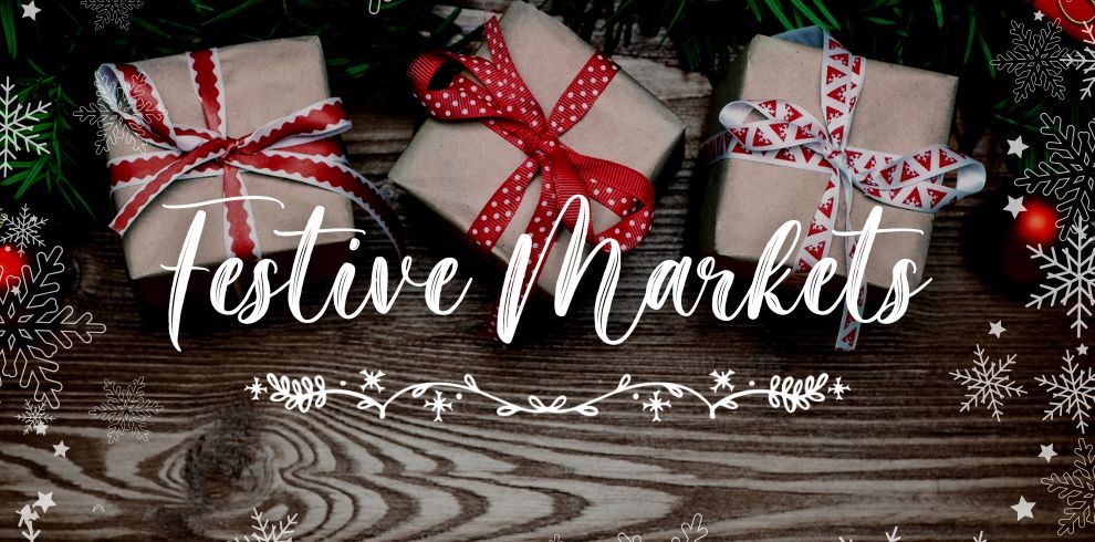 Christmas presents on a wooden table with the words Festive Markets